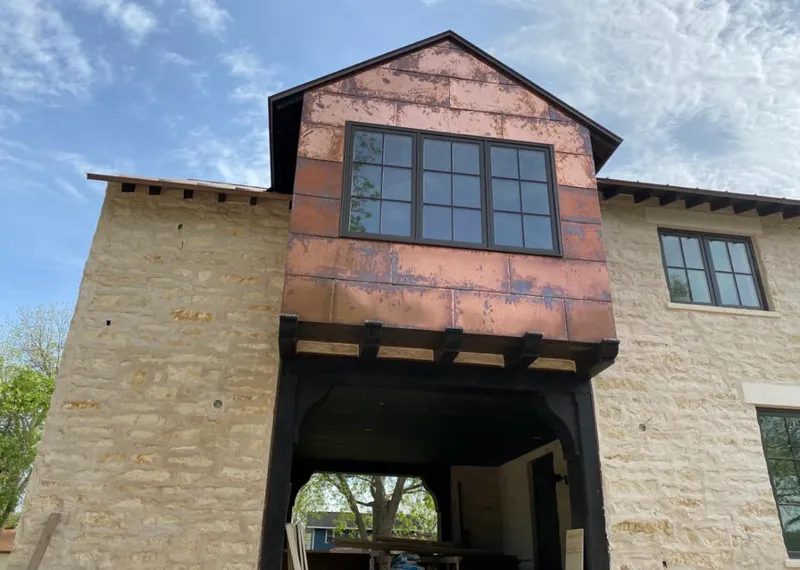 Copper metal panel facade on a stone building for Metal Roof Coating in Charles City