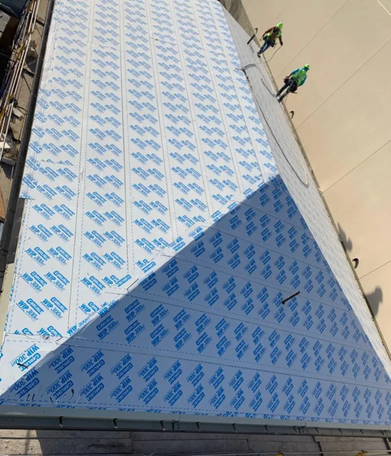 Professional roofers installing underlayment on a metal roof in Charles City